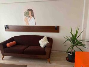 a brown couch in a living room with a picture on the wall at Ferah ve şık cosy daire in Konak