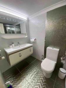 een badkamer met een wit toilet en een wastafel bij Ferah ve şık cosy daire in Konak