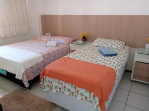 duas camas num pequeno quarto com duas mesas em Apartamento em Fortaleza, Abolição Mucuripe em Fortaleza