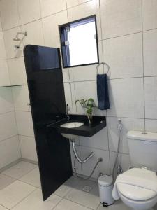 a bathroom with a toilet and a sink and a window at Pousada D Italia in São José da Coroa Grande