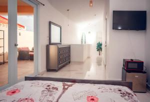 a bedroom with a bed and a television in a room at Paradise Coast Rooftop - Beach Luxury in Isabela