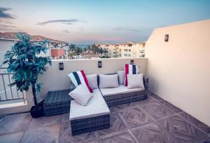 a balcony with two couches and a potted plant at Paradise Coast PR - Vista Mar in Isabela