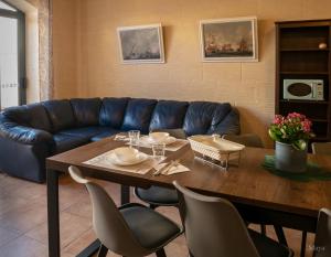 un soggiorno con tavolo e divano blu di Moonshine Villa a Nadur