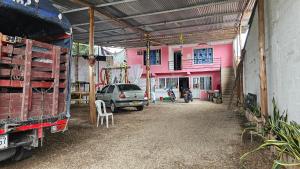 a pink building with a car parked in front of it at El portal del llano in Monterrey