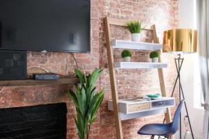 un salon doté d'une étagère avec des plantes en pot dans l'établissement New Prime Gramercy Subway W D in unit, à New York