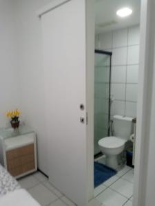 a white bathroom with a toilet and a sink at Apartamento em Fortaleza, Abolição Mucuripe in Fortaleza