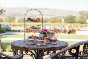 a table with a tray of food and tea pots at Bann at Oak Knoll Napa in Napa