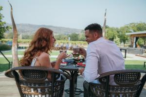 un hombre y una mujer sentados en una mesa con bebidas en Bann at Oak Knoll Napa en Napa