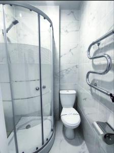 a bathroom with a toilet and a glass shower at Atlas Hotel in Poltava