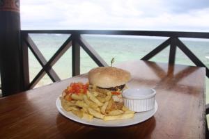 Mana Backpackers and Dive Resort في جزيرة مانا: صحن من الطعام مع ساندويتش وبطاطس مقلية