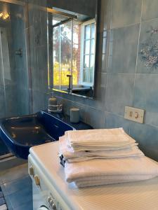 a bathroom with a sink and a mirror and towels at Rouge Cottage nel Roero in Sanfrè