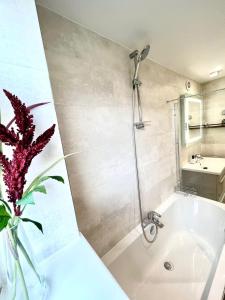Wainscot的住宿－3 Bedroom House in Rochester Strood with Wifi and Netflix Walking distance to Strood Station，浴室设有白色浴缸和花瓶,种植了植物