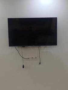 a flat screen tv hanging on a white wall at Résidence kadicia fernuauvil in Oran