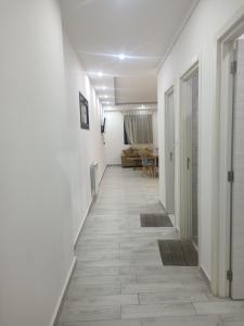 a hallway with white walls and a floor with tiles at Résidence kadicia fernuauvil in Oran