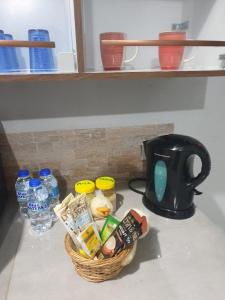 a kitchen counter with a basket of food and a coffee maker at Rooftop Inn Apartments in Piarco