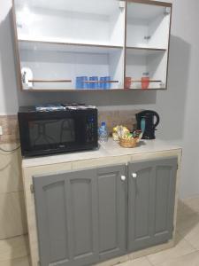 a microwave sitting on top of a counter in a kitchen at Rooftop Inn Apartments in Piarco