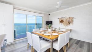 a dining room with a table and chairs with a view at Alcheringa - Units 3 & 4 32 Sandy Point Rd in Corlette