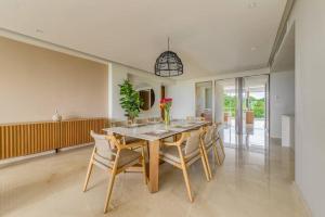 ein Esszimmer mit einem langen Tisch und Stühlen in der Unterkunft New 3BR Condo - Oceanview Terrace - Private Beach in Higuera Blanca
