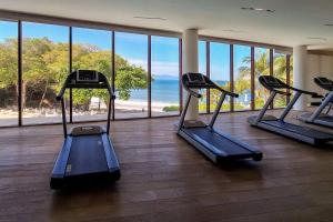 einen Fitnessraum mit Laufbändern und Meerblick in der Unterkunft New 3BR Condo - Oceanview Terrace - Private Beach in Higuera Blanca