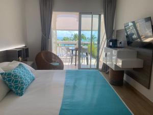 a hotel room with a bed and a view of the ocean at Diamantchery - Vue mer avec Deck privatif in Le Diamant