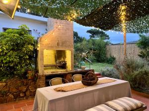 un patio con mesa y horno de piedra en Viento Azul Guest House, en Punta del Este