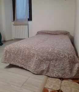 un letto con piumone marrone in una camera da letto di Casa vacanza Città dei Papi Anagni ad Anagni