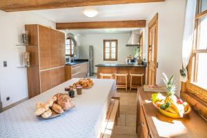 een keuken met een tafel met brood en fruit erop bij Chalet Forest - Luxueuse ferme rénovée - 12 pers in La Rivière-Enverse