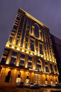 فندق ملاك الصفوة في مكة المكرمة: مبنى مضاء فيه سيارات متوقفة أمامه