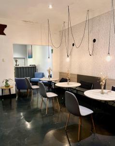 una sala da pranzo con tavoli, sedie e lampadari a braccio di The Lot Boutique a Lima
