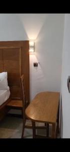 einen Tisch und einen Stuhl in einem Zimmer mit einem Bett in der Unterkunft JAD HOTEL Dschang in Dschang