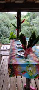 une table avec un tissu de table recouvert de plaques et de plantes dans l'établissement Glowing Mountain view tree house, à Loanengo