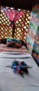 two beds in a teepee with blankets and pillows at Glowing Mountain view tree house in Loanengo