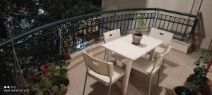 un tavolo bianco e sedie sul balcone di pylaia comfortable apartment 2 a Salonicco