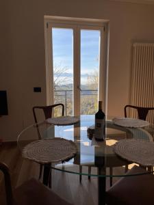 a glass table with a bottle of wine on top of it at Langhetta's house - Alta Langa in Murazzano