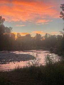 a river with a sunset in the background at Luxurious Bozeman Villa with River access, near the famous Bozeman Hot Springs in Bozeman