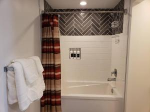 a bathroom with a shower and a bath tub with towels at Luxurious Bozeman Villa with River access, near the famous Bozeman Hot Springs in Bozeman