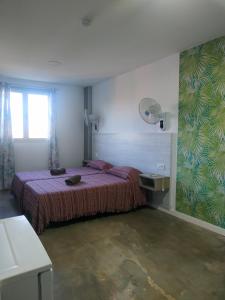 a bedroom with a bed and a table and a window at Alojamiento Gofioplaya in Arinaga +174 photos
