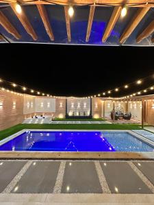 una piscina en una casa con luces en Cabaña la arenosa, en Barranquilla