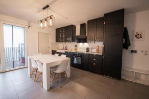 a kitchen with a table and a white table and chairs at Spacious apartment near the beach in Bordeaux