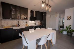 cocina con mesa blanca y sillas blancas en Spacious apartment near the beach en Burdeos