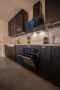 a kitchen with black cabinets and a stove top oven at Spacious apartment near the beach in Bordeaux