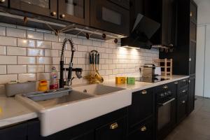 a kitchen with a sink and black cabinets at Spacious apartment near the beach in Bordeaux