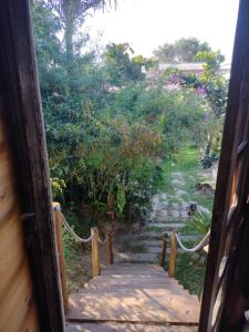 uma porta que conduz a um jardim com um caminho de madeira em Recanto da minha flor - Praia da Pinheira em Palhoça