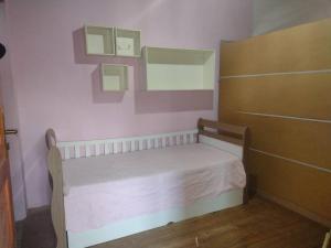 um pequeno quarto com uma pequena cama e um espelho em Recanto da minha flor - Praia da Pinheira em Palhoça