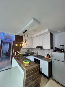 une cuisine avec des placards blancs et un comptoir en bois dans l'établissement Appartement marina hammamet, à Hammamet