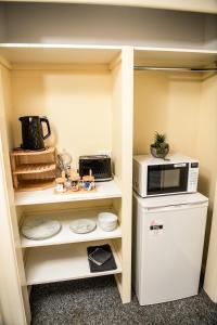a small kitchen with a microwave and a refrigerator at Hills of Gold Motel at Nundle in Nundle