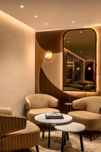 a room with two chairs and a table and a mirror at Hilton London Metropole in London