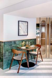 una sala da pranzo con tavolo e 2 sedie di Hilton London Metropole a Londra