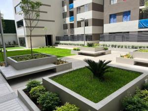een binnenplaats van een gebouw met planten en gras bij Depa moderno y tranquilo a 15 min del Aeropuerto in Lima
