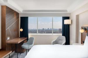 Cette chambre comprend un grand lit et une fenêtre. dans l'établissement Hilton London Metropole, à Londres